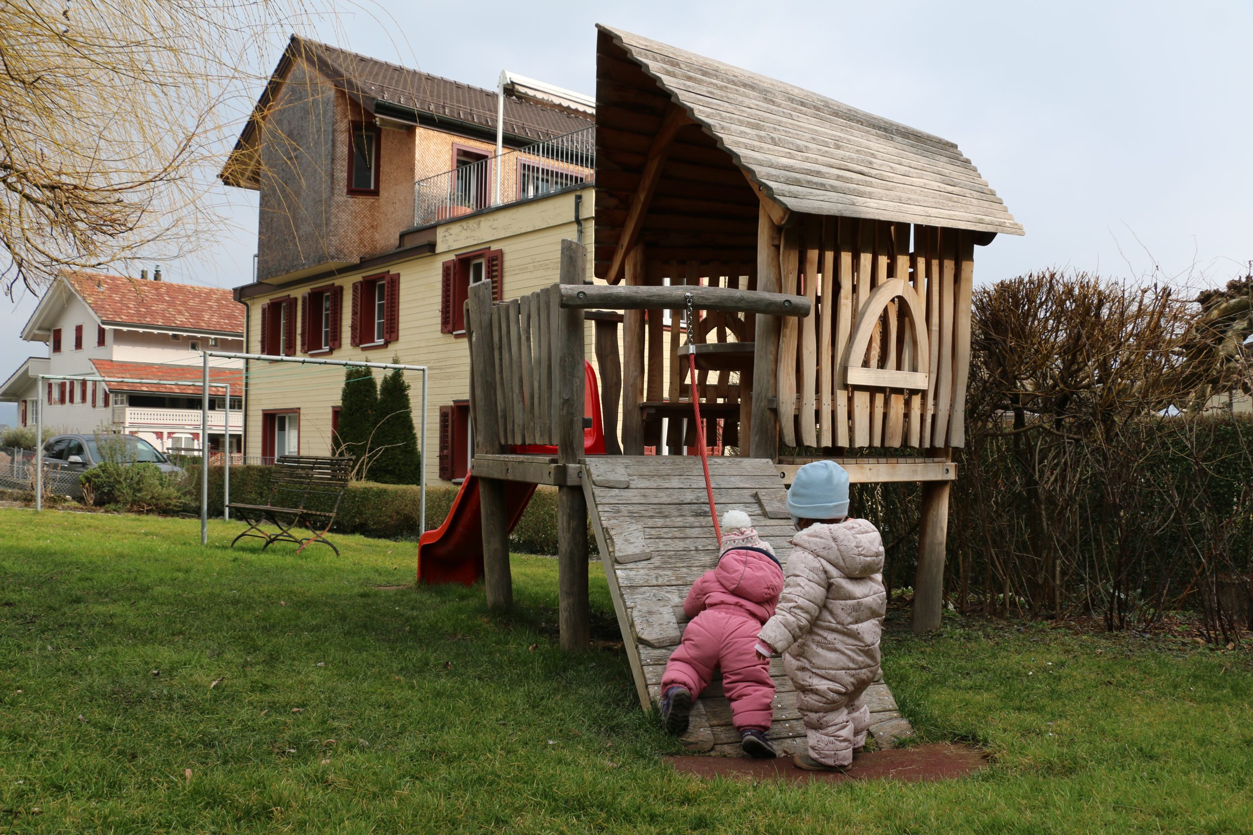 Holzspielhaus mit zwei Kindern